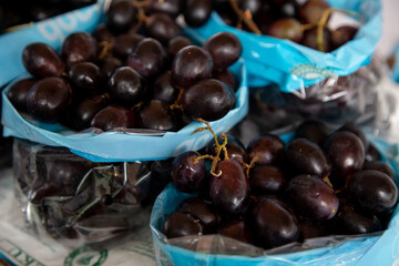 Selective focus shot of delicious black grapes in the market