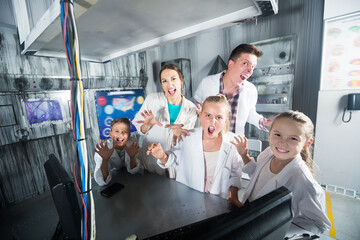 Adult family is visiting of escape room stylized under laboratory