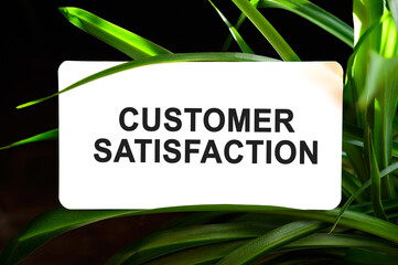 Customer Satisfaction text on white surrounded by green leaves