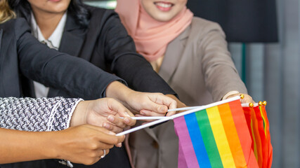 Five business women from different ethnic races and cultures  express support for LGBT with flags...