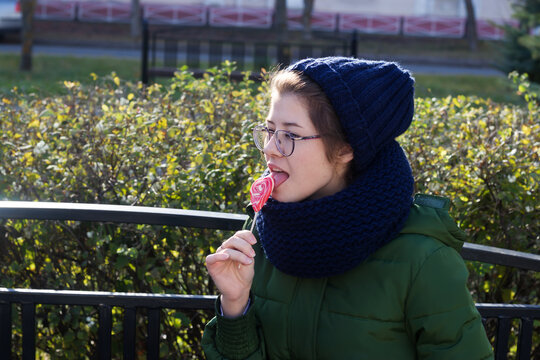 young girl eats a candy in the form of a heart