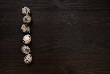 Quail eggs on a dark wooden background. Delicious and healthy Breakfast, lifestyle, ingredients for cooking different dishes. Photo of food.