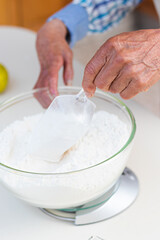 Hands of an old man weighing ingredients