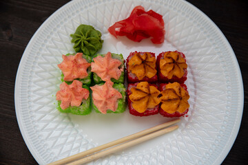 Set of eight sushi rolls on a white plate with salmon, eel, tuna, avocado, king prawn, cream cheese, tobiko caviar, Chuka. The sushi menu. Japanese cuisine. Top view of assorted sushi.