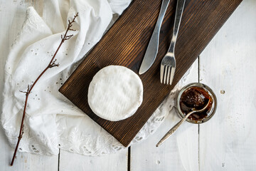 A type of Brie cheese. Camembert cheese. Fresh brie cheese and slice on a wooden board. Italian, French cheese. view from above