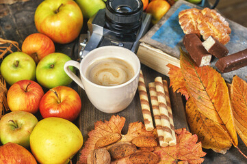 A Cup of hot autumn coffee with fruit and sweets on the table