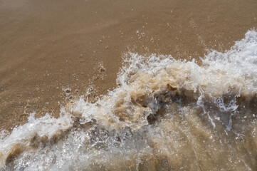 Sea surf, waves rolls on a sandy beach