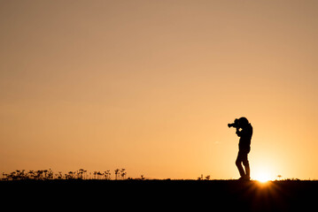 朝焼けの風景を撮影するカメラマン