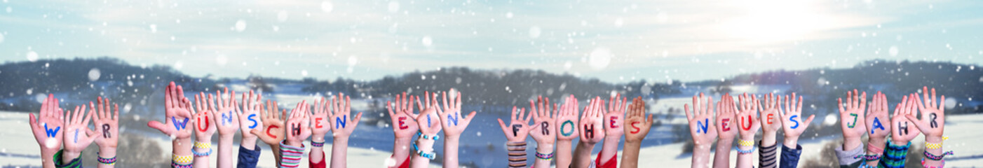 Children Hands Building Colorful German Word Wir Wuenschen Ein Frohes Neues Means Happy New Year. Snowy Winter Background With Snowflakes