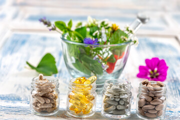 Holistic medicine approach. Healthy food eating, dietary supplements, healing herbs and flowers. wooden background, c.
