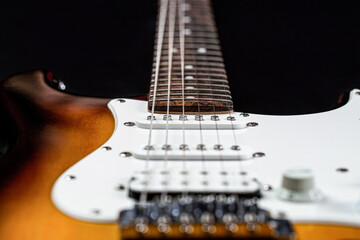 Fototapeta na wymiar Electric guitar. Close up of music guitar. Stringed electric musical instrument. Musical instrument for rock, blues, metal songs. Guitar strings, close up. Electric Bass Guitars