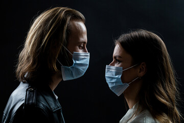 Couple wearing a protective face mask, pandemic and feelings concept. Lifestyle COVID-19. Faces of people in protective masks from coronavirus. Beautiful quarantined couple