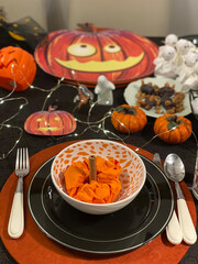 Halloween table. Dinner place setting. Jack o lanterns on decorated table for Halloween
