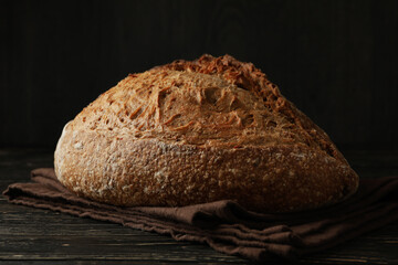 Towel with fresh baked bread on wooden table
