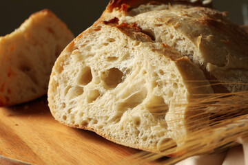 Board with fresh bread and spikelets, close up