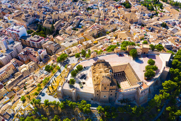 Fototapeta premium Aerial view of Caravaca de la Cruz cityscape with ancient fortified castle and Roman Catholic church, Spain