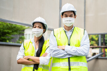 Asian young engineer man and woman wear face mask to prevent COVID-19.