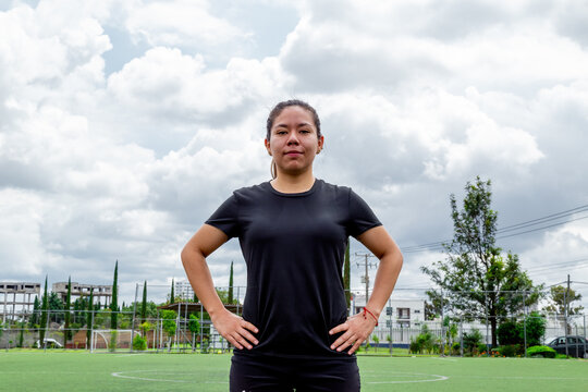 Low angle shot of a young Hispanic football player in sportswear posing in a training field