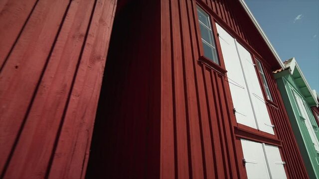 Sm&Atilde;&para;gen pier colorful wooden houses. Red yellow and green fishing cabins on sunny day in Bohusl&Atilde;&curren;n Sweden. Famous swedish tourist attraction small fisher storage building. Sun on white framed window
