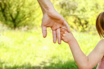 the parent holding the child's hand with a happy background