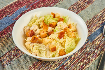 Closeup of fresh salad with croutons on table in cafe