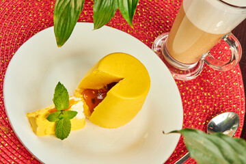 Yellow mini cake covered with yellow glaze on table in cafe close up