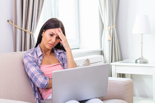 Young frustrated woman working from home in front of laptop suffering from chronic daily headaches, treatment online, appointing to a medical consultation, electromagnetic radiation, sick pay