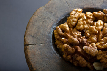 Walnuts in antique, wooden mortar.