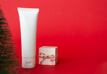 White cosmetic cream tube and gift box with red white striped twine rope