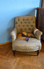 A romantic straw hat on a comfortable upholstered armchair