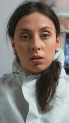 Raw shaky portret of tired doctor in coverall taking off the mask looking on camera after examining patient during coronavirus pandemic. Dentist nurse wearing coverall, face shield, mask, gloves in © DC Studio