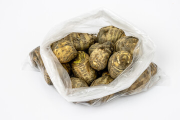 Fresh organic jerusalem artichoke inside of transparent white polythene isolated on white background