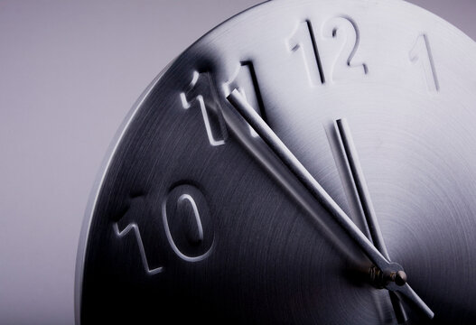 Close Up Of A Clock Showing Five Minutes To Twelve. Counting Down To Midnight.