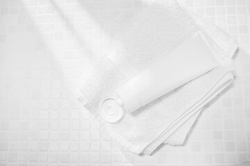 洗顔料などのスキンケア系の容器とタオル