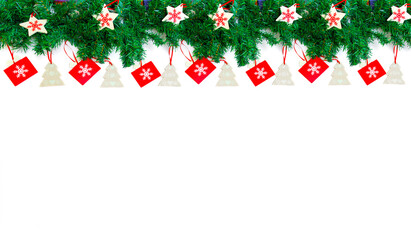Garland of fir branches decorated with Christmas toys. White background with the decor located at the top.