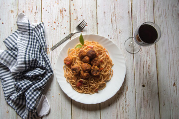 View from of meatballs and spaghetti pasta along with a drink on a background