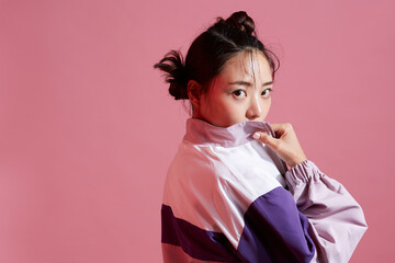 スポーティーなファッションコーディネートをしたグリッターメイクの若い女性