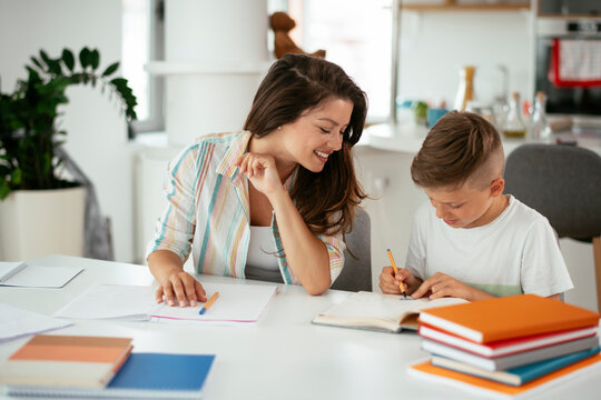 Mother helping her son with homework at home. Little boy learning at home..
