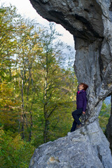 Woman hiker standing on the cliff in a doline