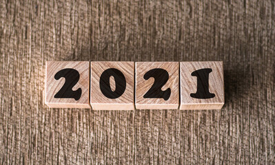 new year concept. font 2021 on wooden cubes on brown background for banner