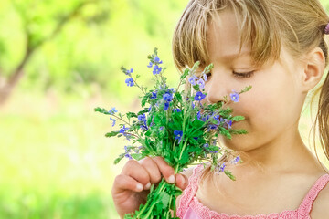 A Happy girl on nature in the park with flowers