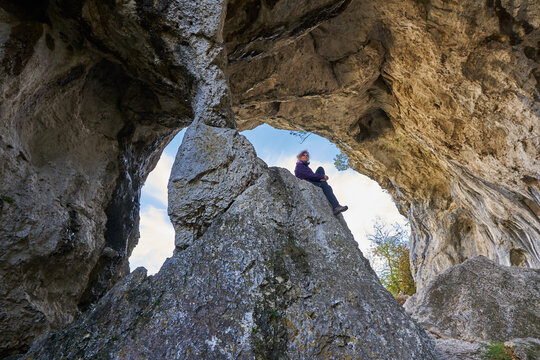 Woman hiker standing on the cliff in a doline