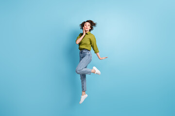 Photo portrait of woman sending kiss jumping up hand near face isolated on pastel light blue colored background