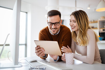 Beautiful couple working on a tablet at home