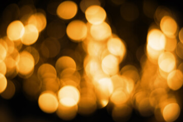Fototapeta premium Defocused golden bokeh on black background. abstract background. Christmas bokeh