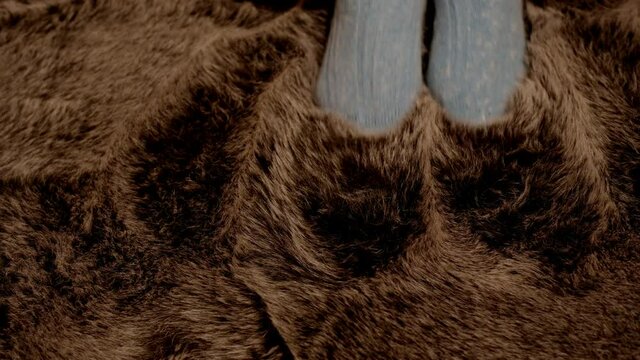 Frau in Angora Socken genie&szlig;t und streichelt sich in einem Schafsfell  