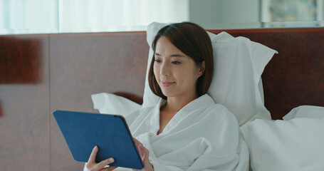 Woman use of tablet computer on bed