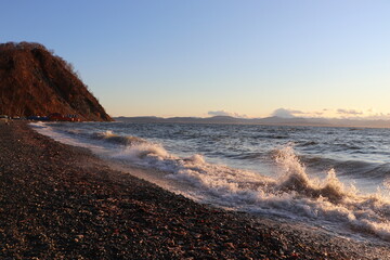 waves hit the shore at sunset