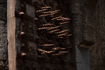 close shot of door spikes for defense against elephant attack isolated in Kalaburagi fort back entrance gate
