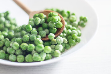 green peas in a white plate on a white background